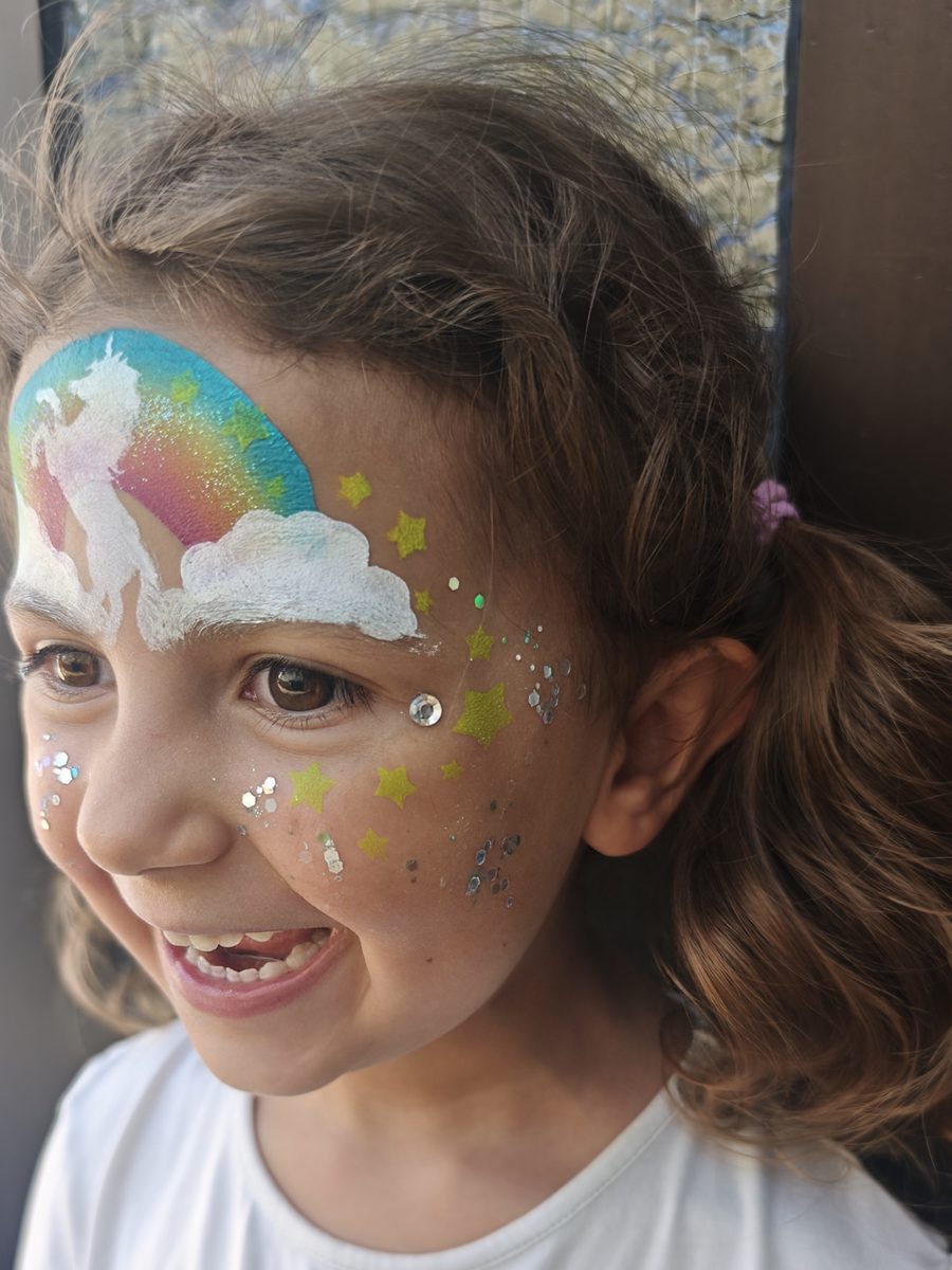 Kinderschminken: Einhorn-Regenbogen mit Sternen und Glitzer, seitlich